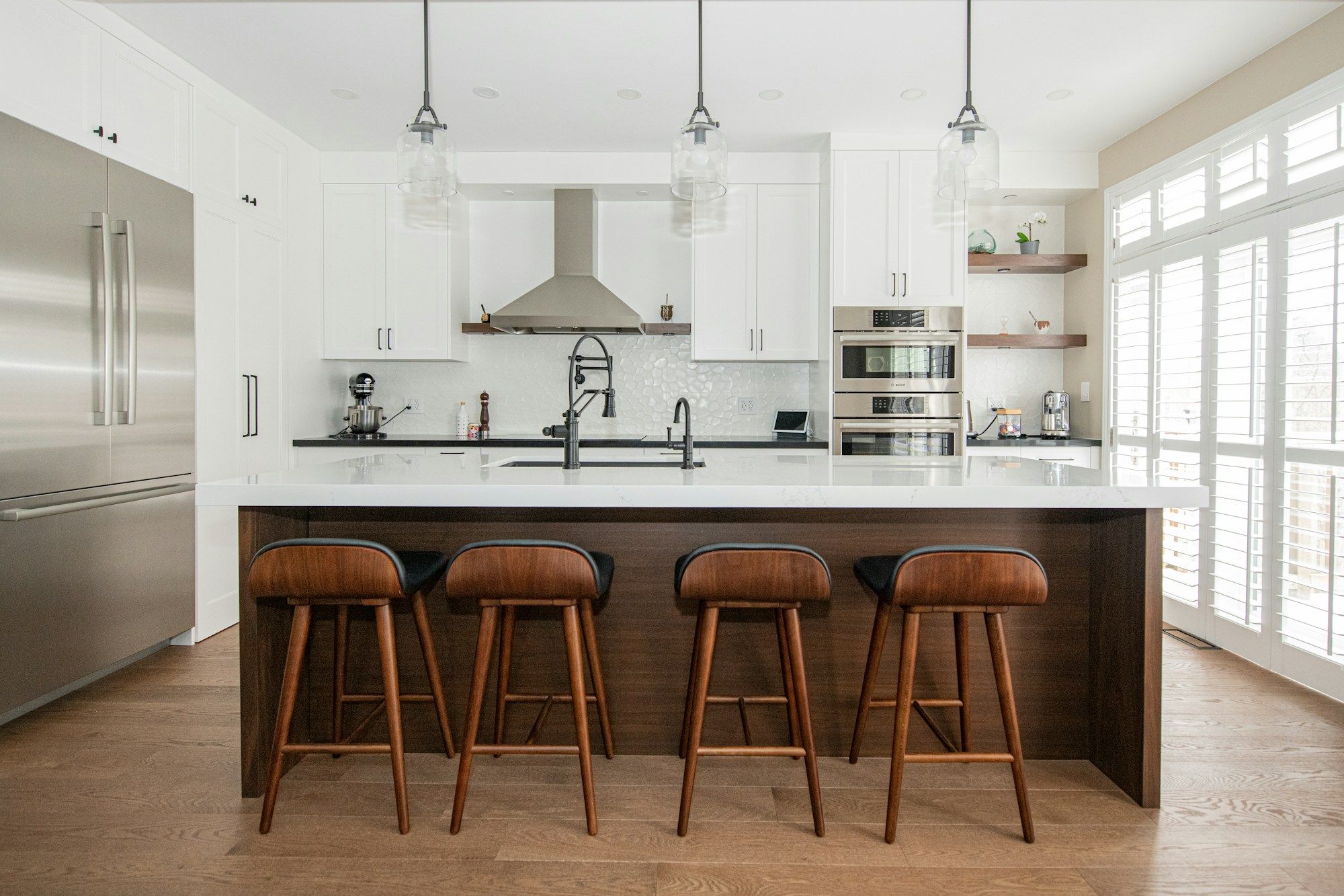 Cocina con isla de madera y taburetes, vista amplia